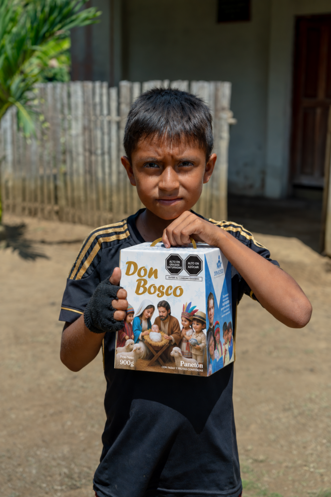 Niño sosteniendo una caja de Panetón Don Bosco.